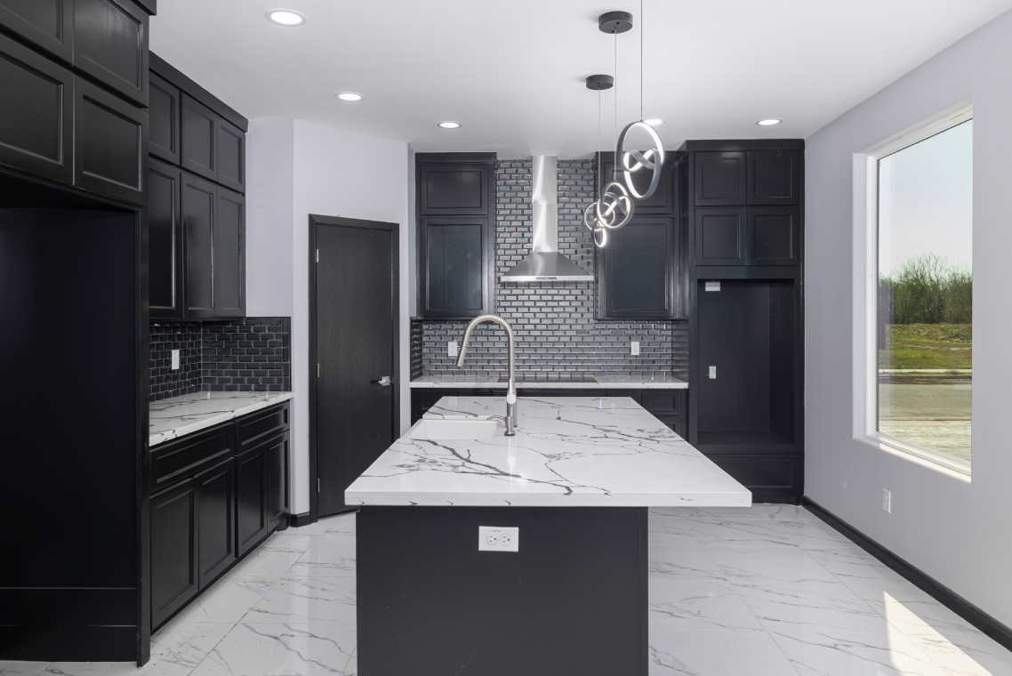 Kitchen with marble countertop and black cabinets