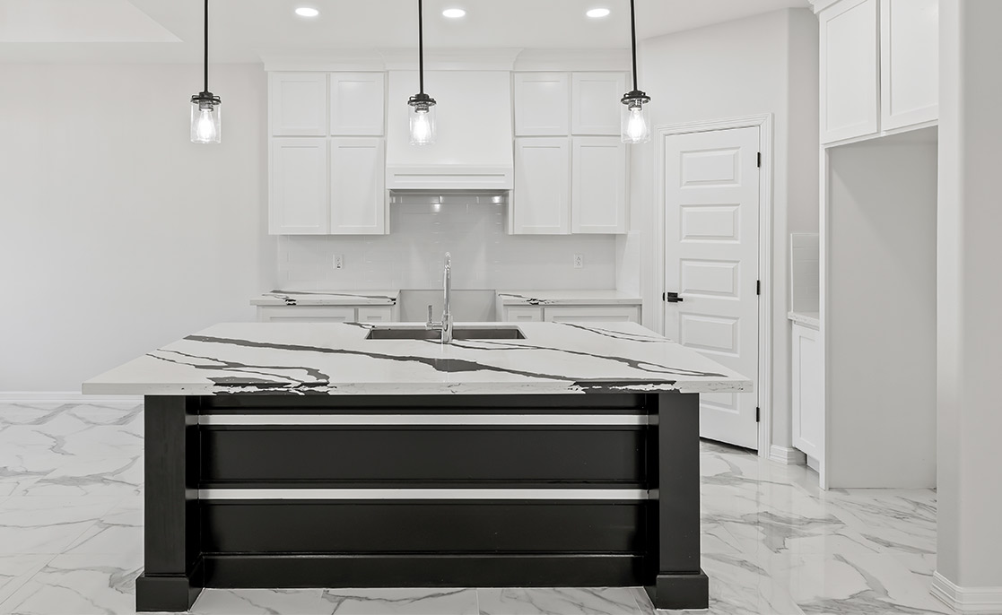 A contemporary kitchen showcasing polished marble countertops and bright white cabinets, emphasizing a clean and upscale look.