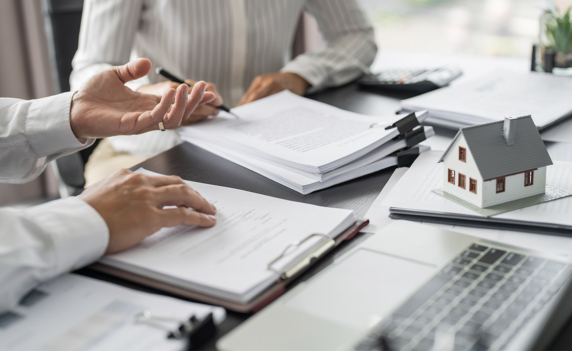 A real estate agent advises a client on purchasing a house, emphasizing tips for choosing a custom home builder in McAllen.