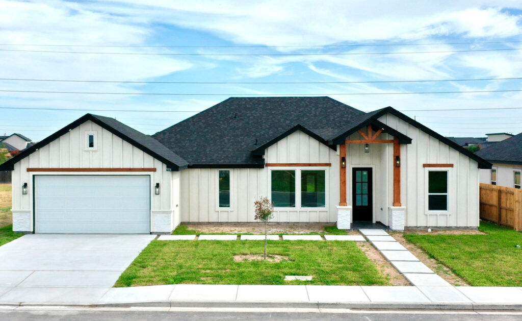 Newly constructed two-story house featuring a garage and driveway in McAllen, Texas.