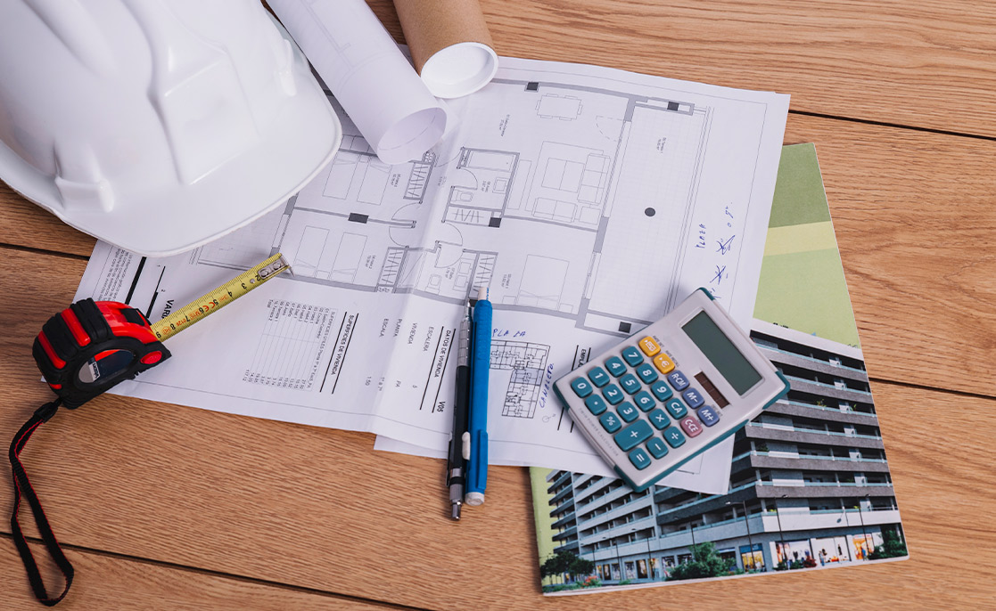 Tools including a hard hat and calculator on a construction site for a new home in McAllen, Texas.