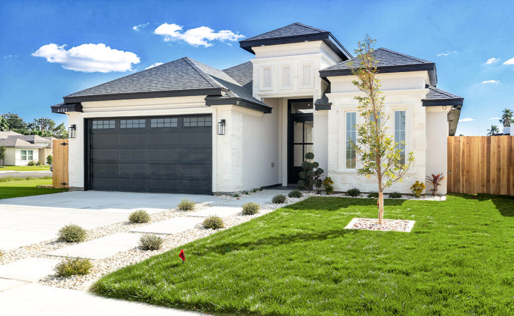 A residential house featuring a garage and a green lawn, relevant to choosing the right lot in McAllen.