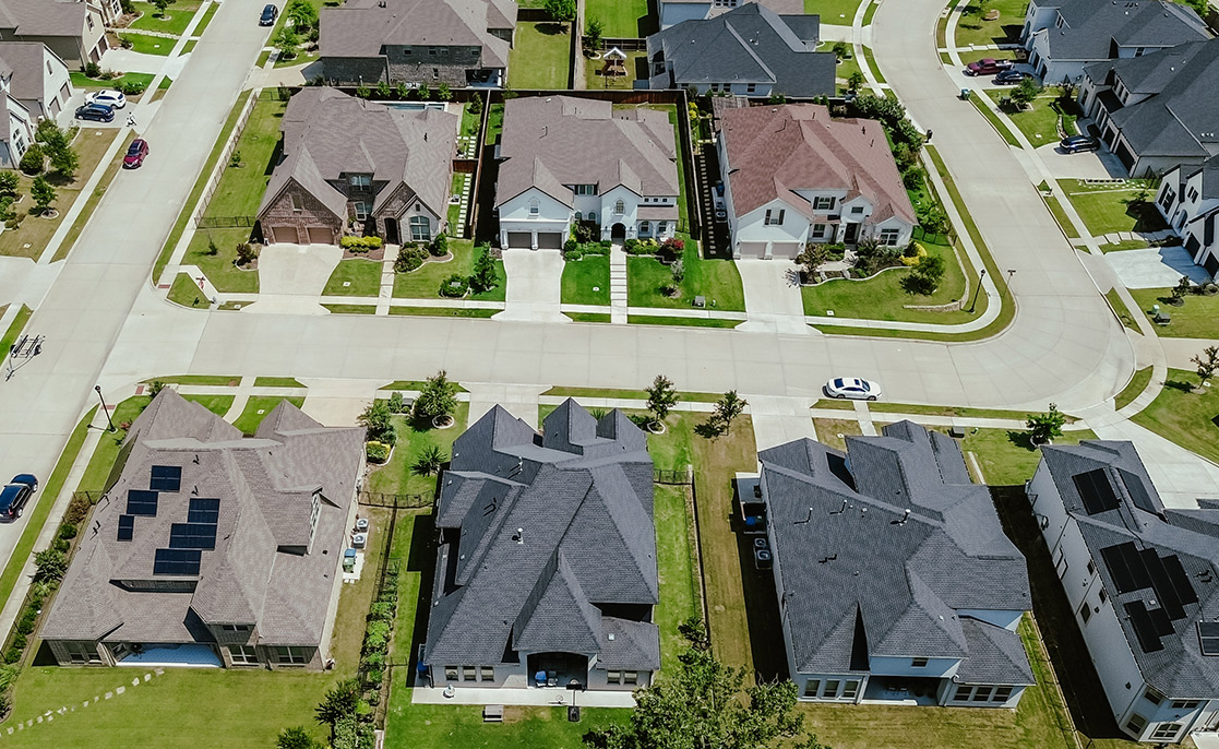 Overhead perspective of a residential area with homes and vehicles, relevant to selecting a lot for new construction in McAllen.