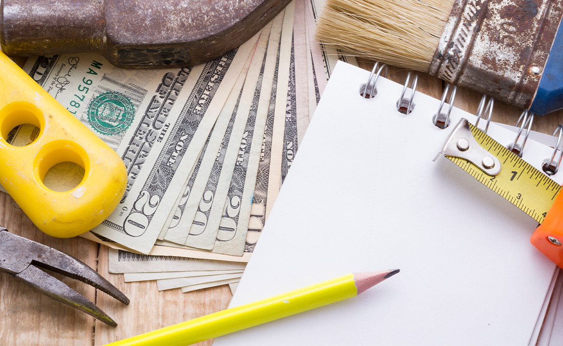 A collection of building tools and stationery: notepad, pencil, hammer, ruler, pen, screwdriver, screws, nails.